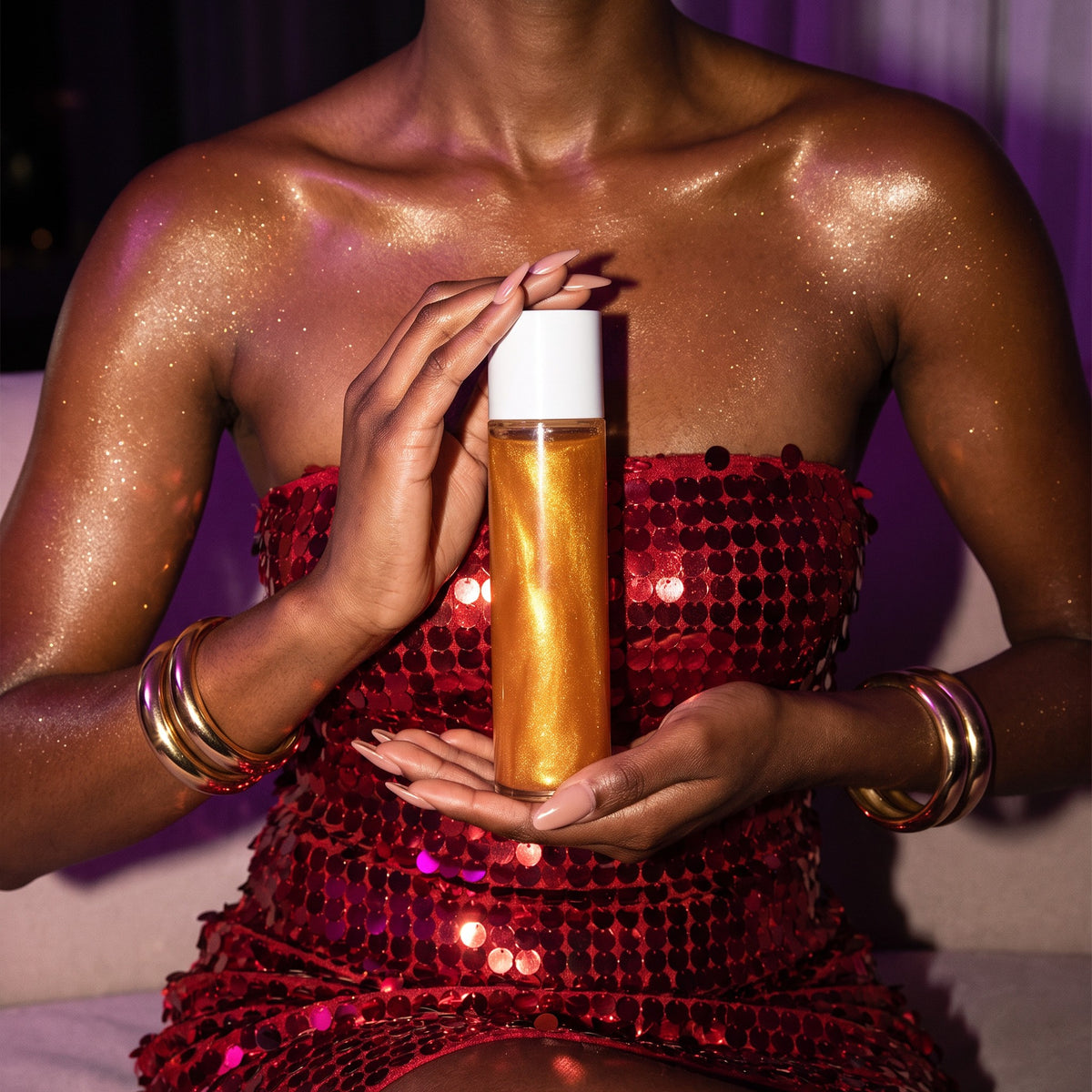 Gold shimmer on deep skin in a red sequin dress, holding a bottle of Molten Gold