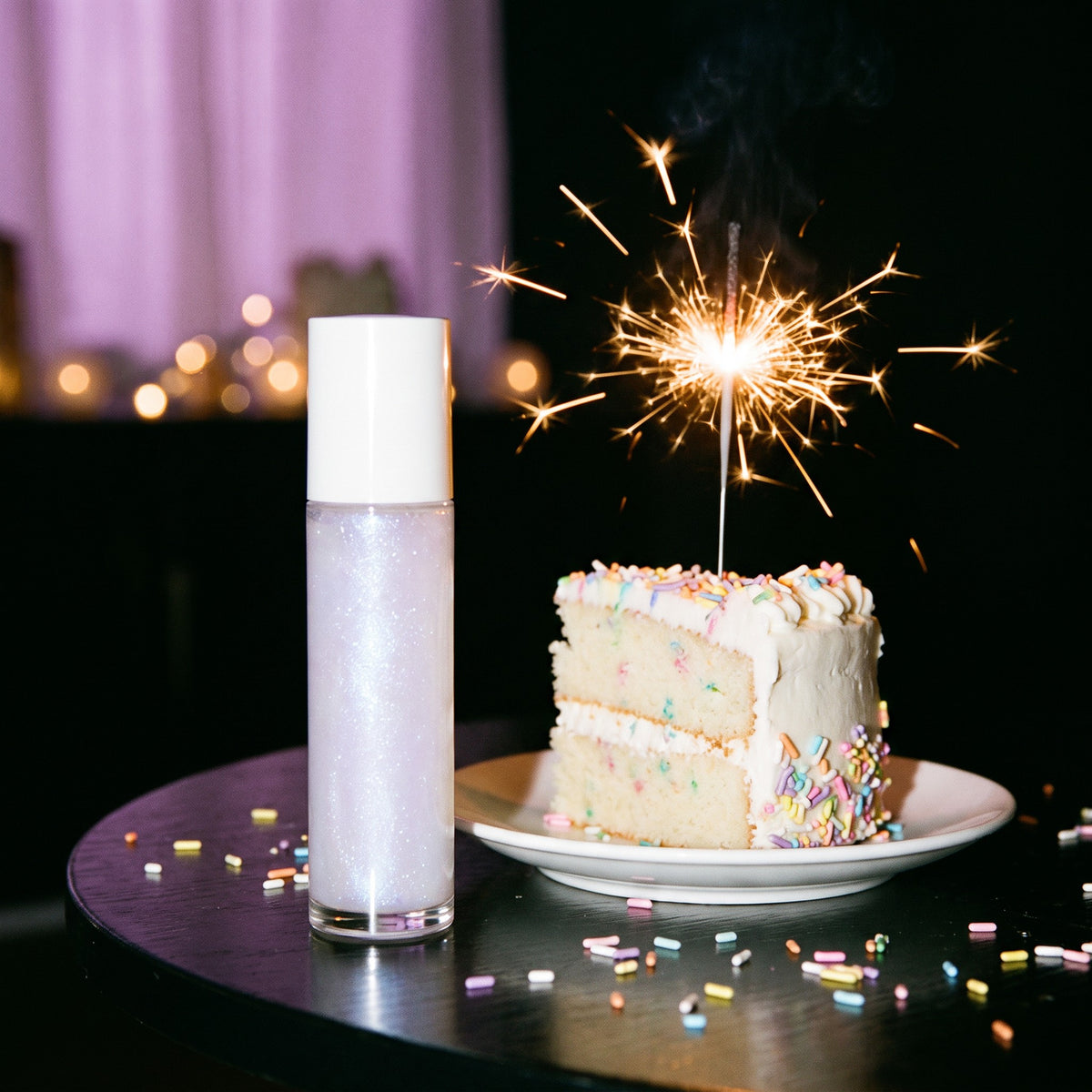 Lilac Pearl shimmer body oil with birthday cake and a sparkler