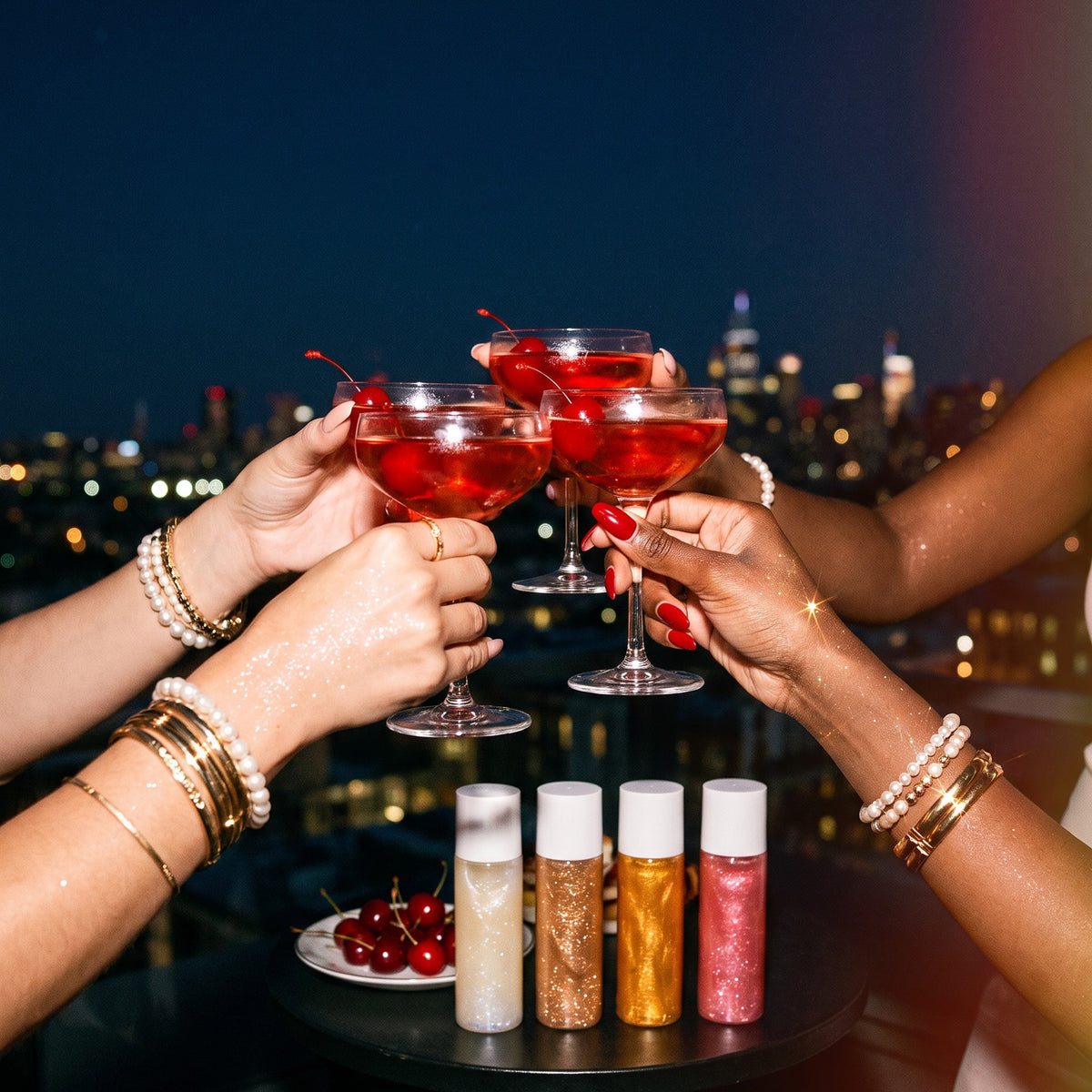 Friends toasting with cherry cocktails on a rooftop at night, shimmer on their wrists
