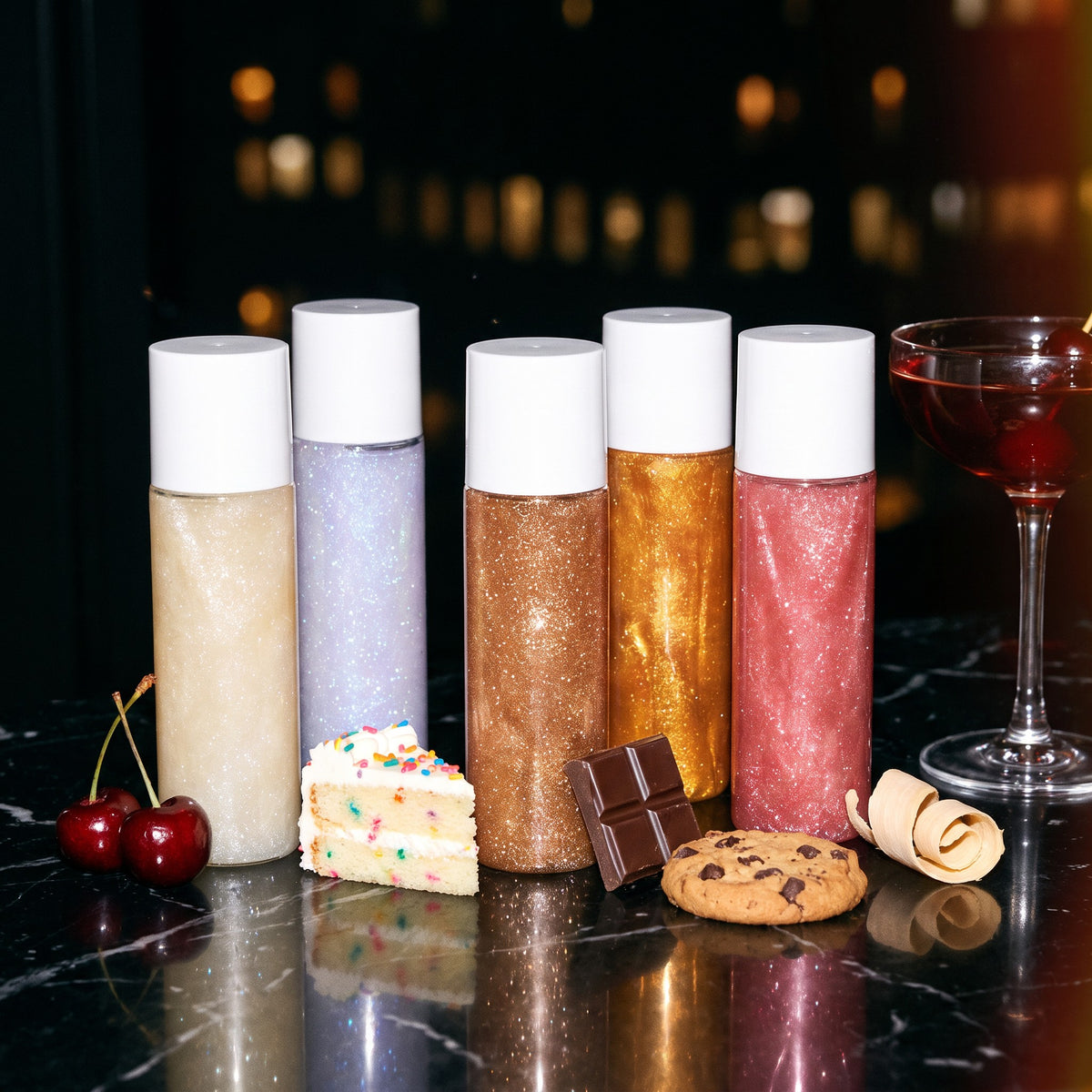 All five Sugarcoat shades on a black marble bar with desserts